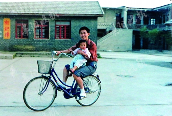 　1993年，商蜀西抱着女儿骑车在校园里.jpg